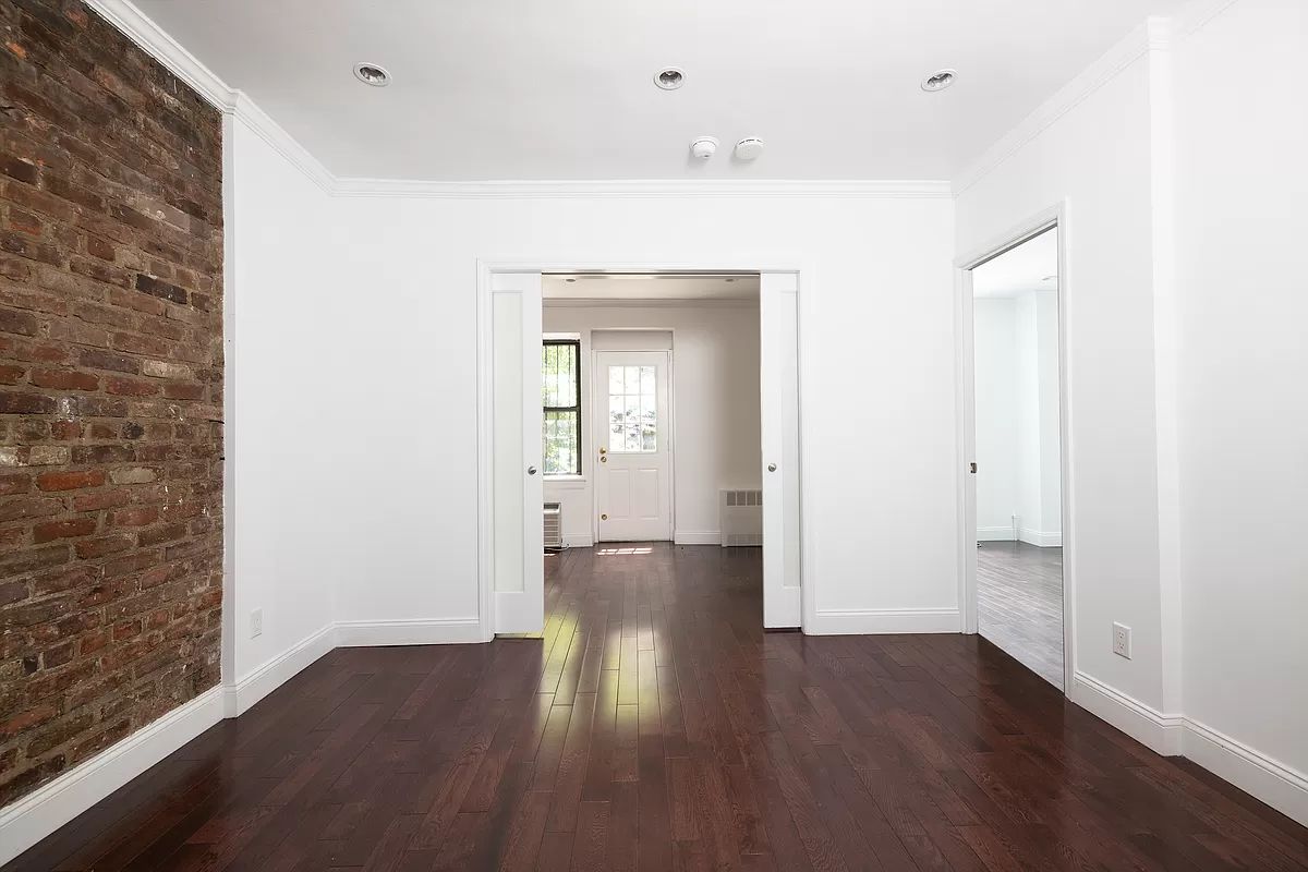 328 West 19th Street, Unit 1B Manhattan, NY 10011 - Photo 3 of 11 wooden floor in an empty room with a window