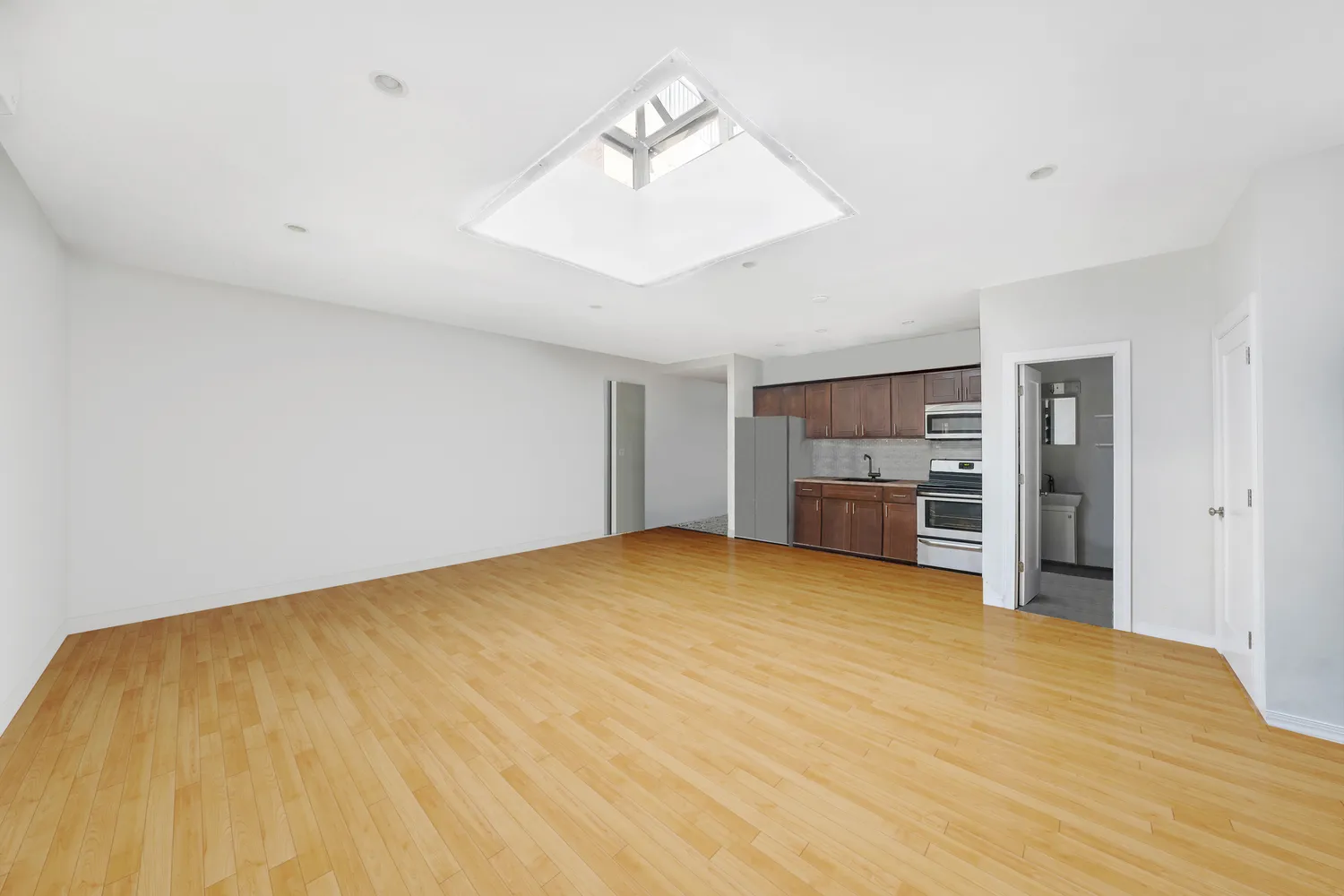 a view of empty room with kitchen