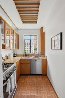 a large kitchen with granite countertop a stove top oven a sink dishwasher and wooden cabinets