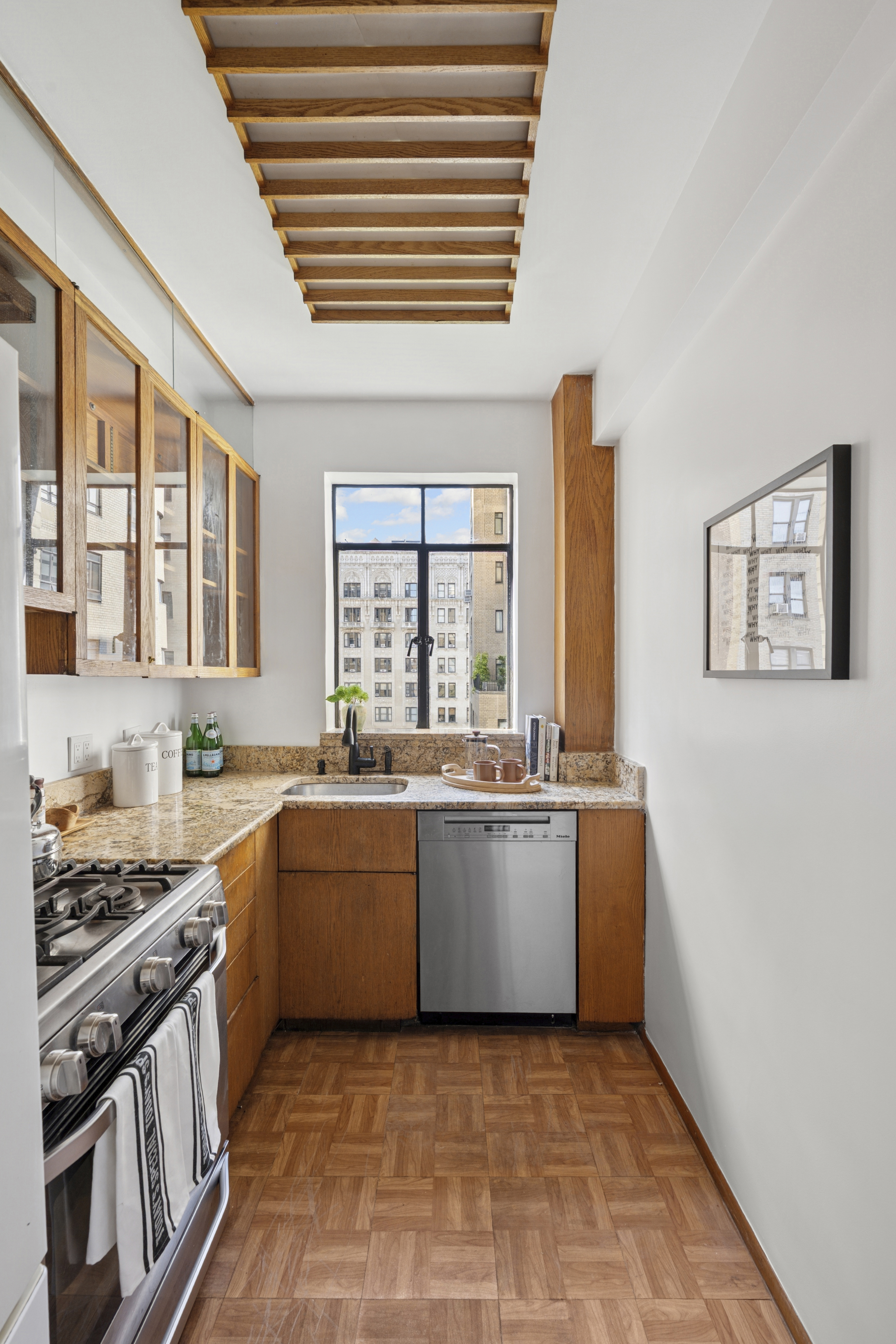 140 Riverside Drive, Unit 10N Manhattan, NY 10024 - Photo 15 of 21 a large kitchen with granite countertop a stove top oven a sink dishwasher and wooden cabinets