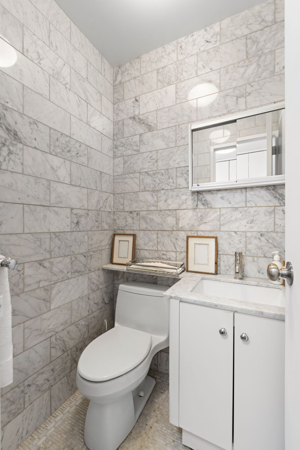 400 East 54th Street, Unit 18E Manhattan, NY 10022 - Photo 13 of 22 a bathroom with a granite countertop toilet sink and mirror