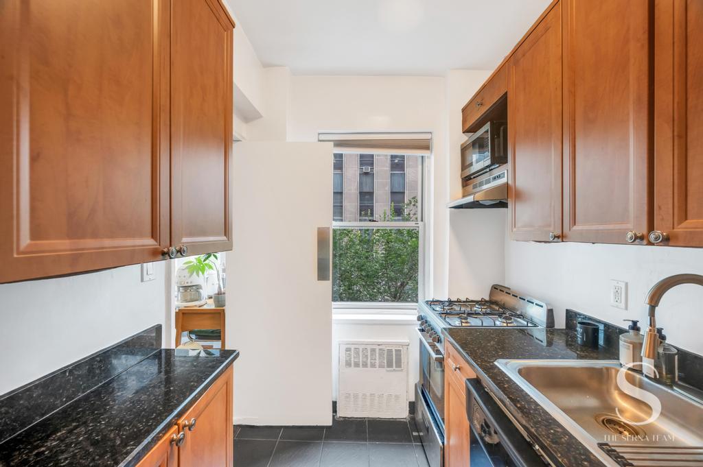 7 Lexington Avenue, Unit 5E Manhattan, NY 10010 - Photo 16 of 27 a kitchen with granite countertop a sink stove and cabinets