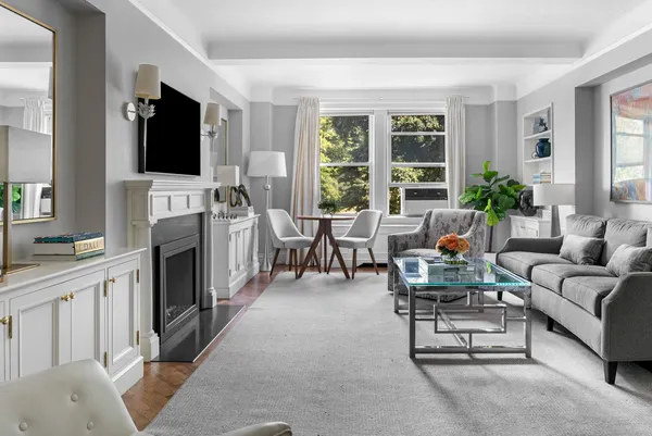 a living room with furniture a flat screen tv and a fireplace