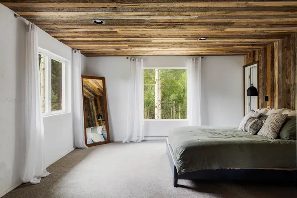 a bedroom with a bed and a large window