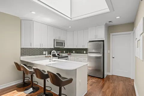 a kitchen with refrigerator cabinets dining table and chairs