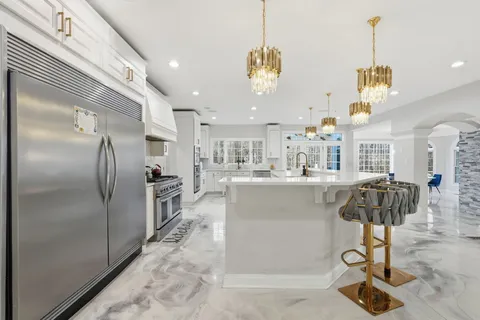 a kitchen with kitchen island a counter top space appliances and cabinets