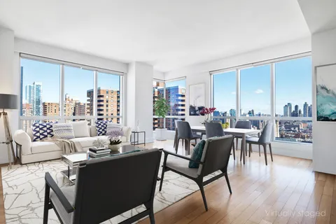 a living room with furniture wooden floor and a large window