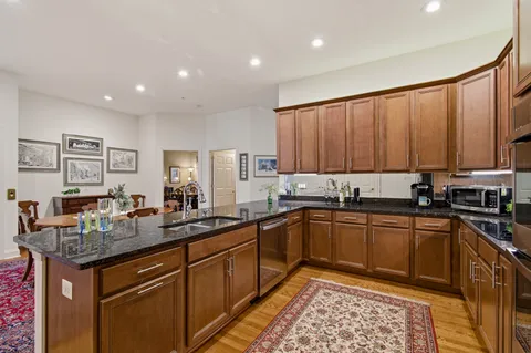 a kitchen with stainless steel appliances granite countertop sink stove and cabinets
