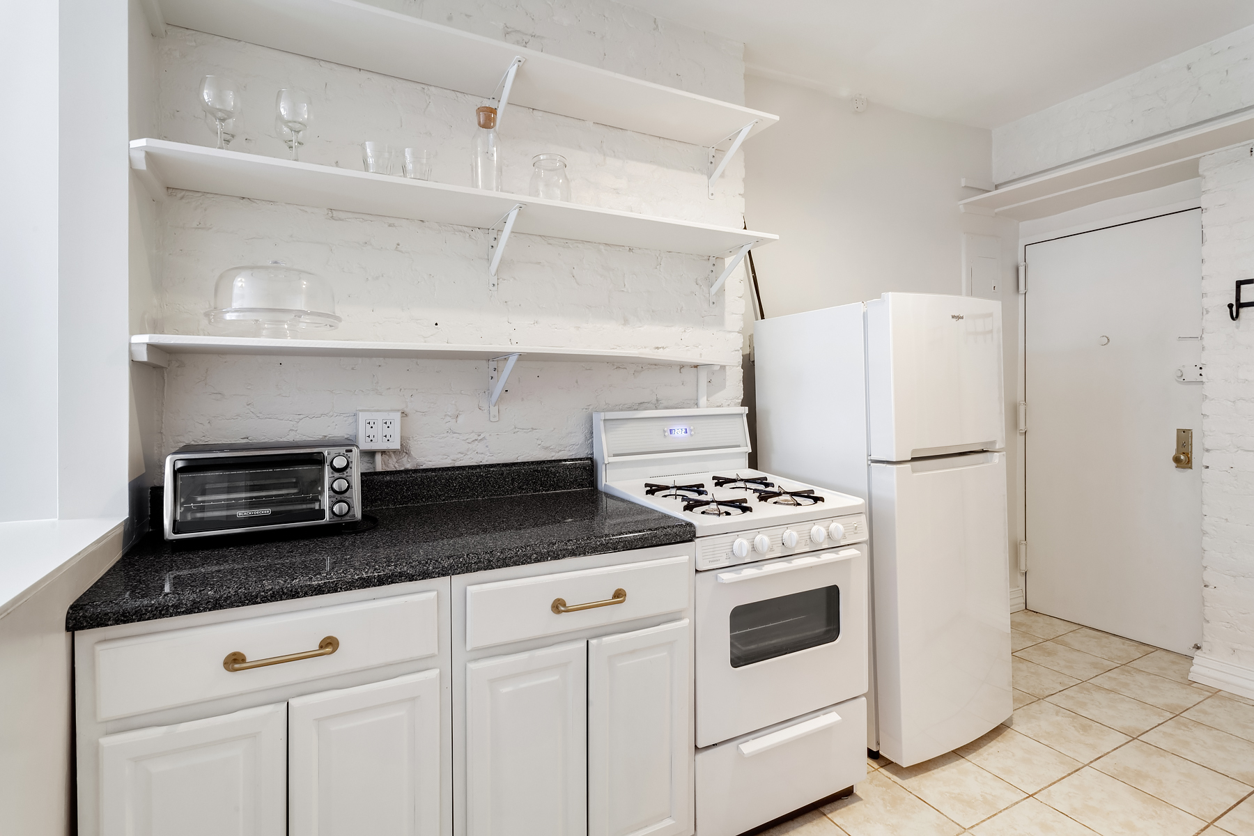 181 Thompson Street, Unit 19 Manhattan, NY 10012 - Photo 5 of 7 a kitchen with stainless steel appliances granite countertop a refrigerator a stove and white cabinets