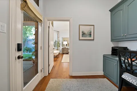 a view of a hallway with wooden floor and furniture
