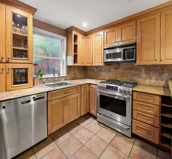 a kitchen with granite countertop a sink stainless steel appliances and cabinets