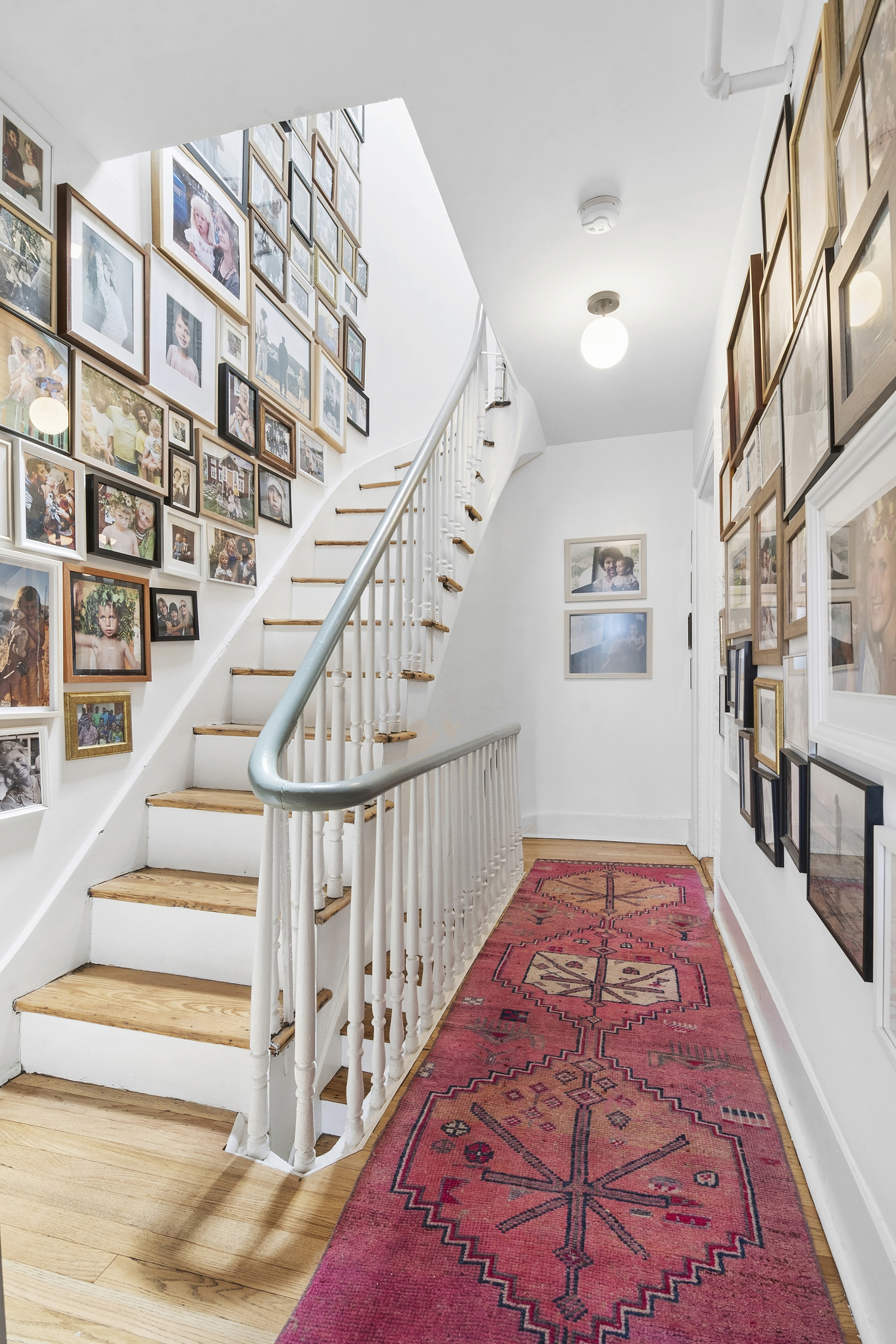 190 Concord Street Brooklyn, NY 11201 - Photo 5 of 14 a view of staircase with lots of frames on wall and a rug
