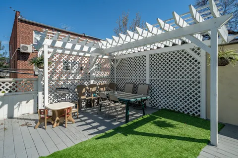 a view of a chairs and table in patio with wooden fence