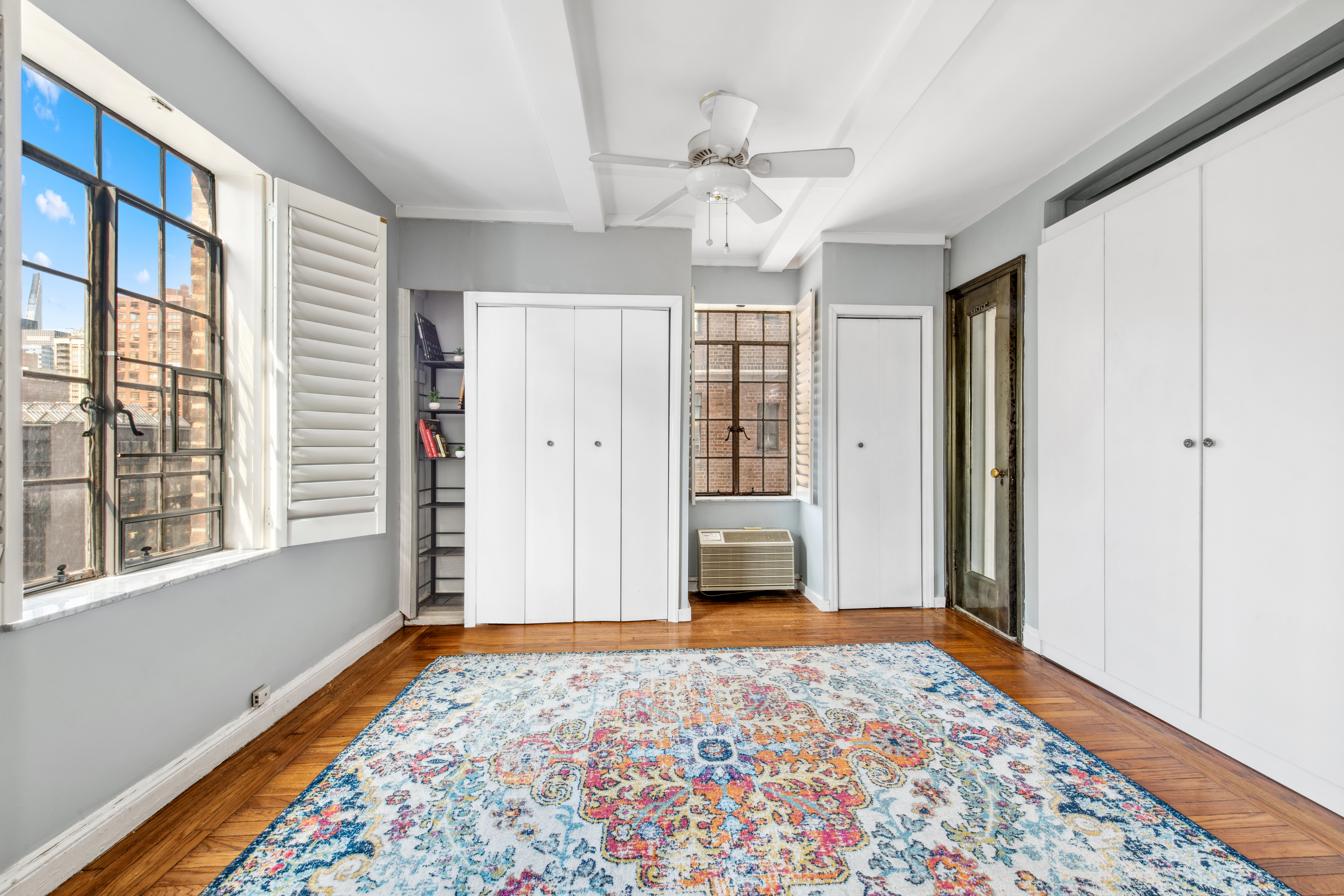 25 Tudor City Place, Unit 1419 Manhattan, NY 10017 - Photo 4 of 14 a view of an empty room with a window and wooden floor