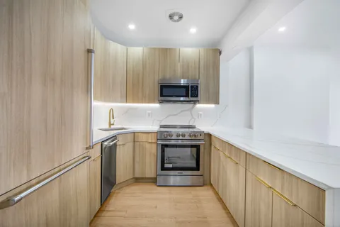 a kitchen with stainless steel appliances granite countertop a stove and a refrigerator
