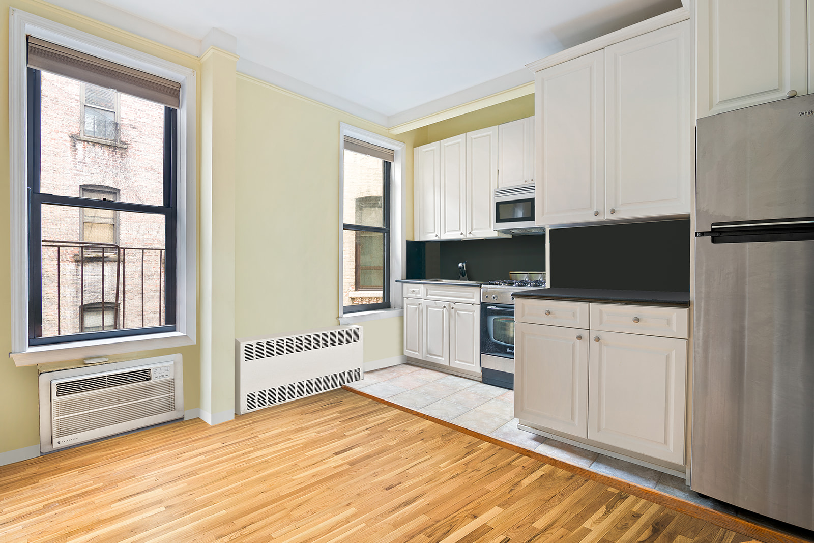 a kitchen with white cabinets and appliances