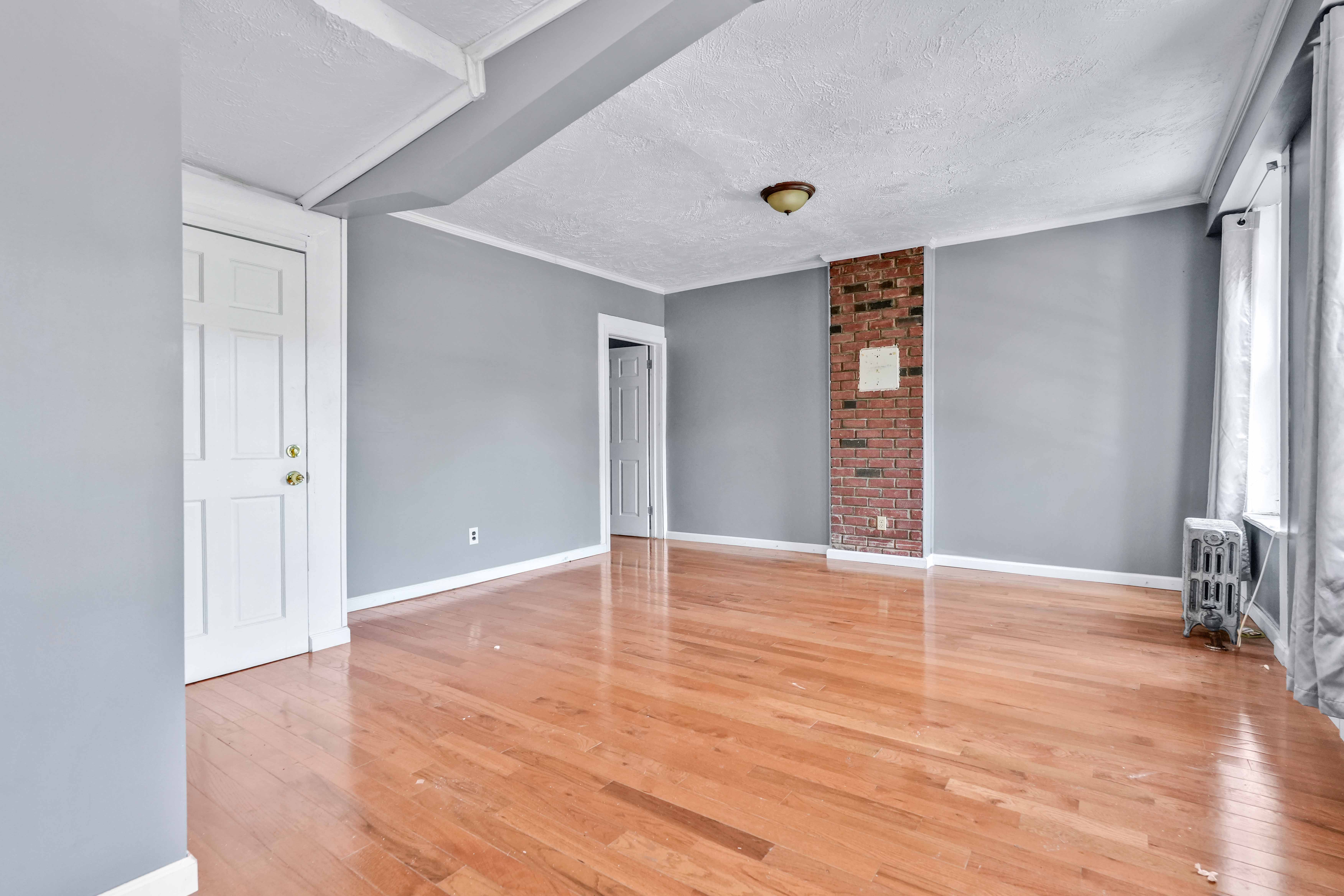 610 Ashford Street Brooklyn, NY 11207 - Photo 5 of 28 a view of an empty room with wooden floor and a window