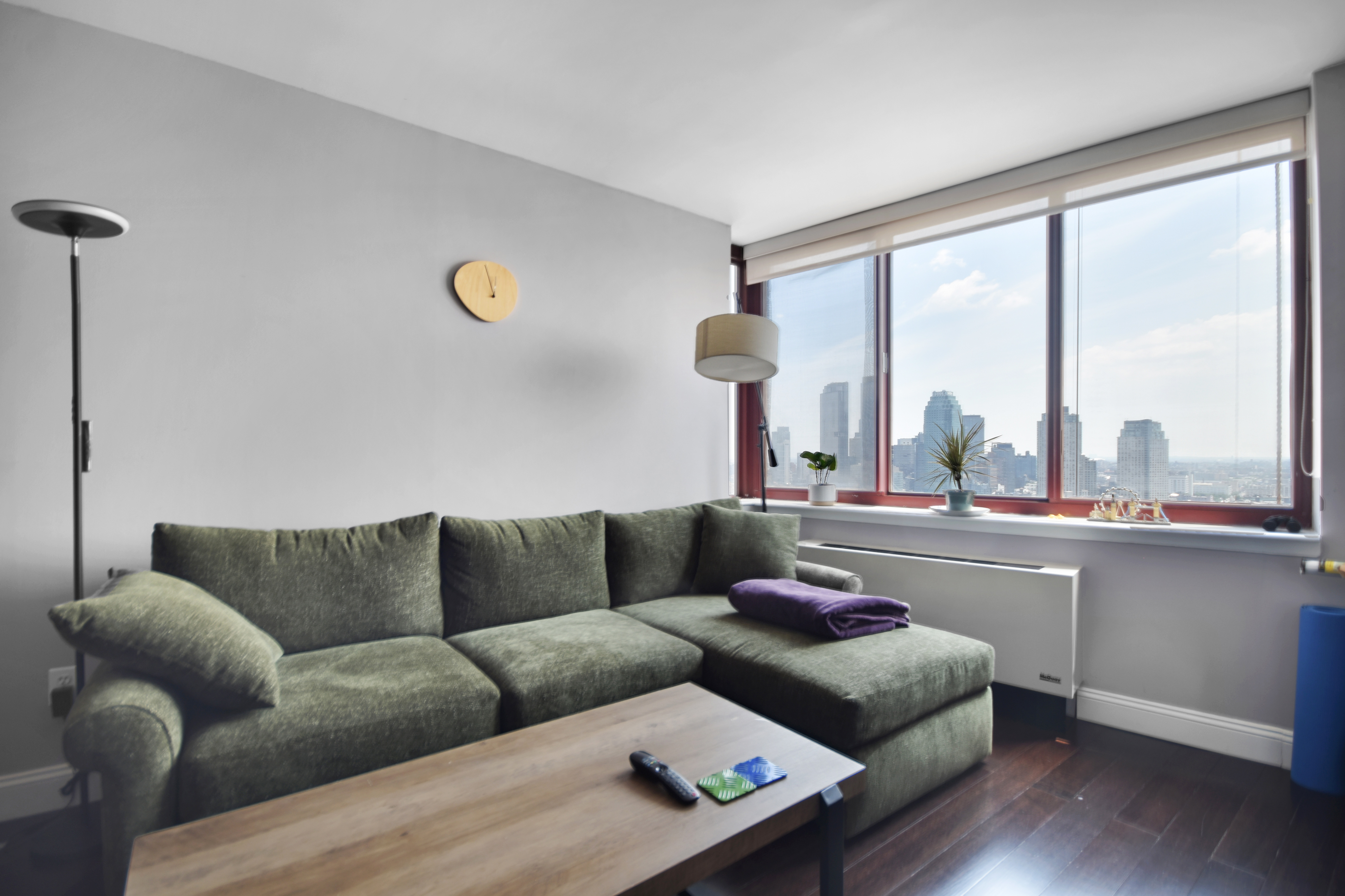 4-74 48th Avenue, Unit 34G Queens, NY 11109 - Photo 2 of 9 a living room with furniture and a large window