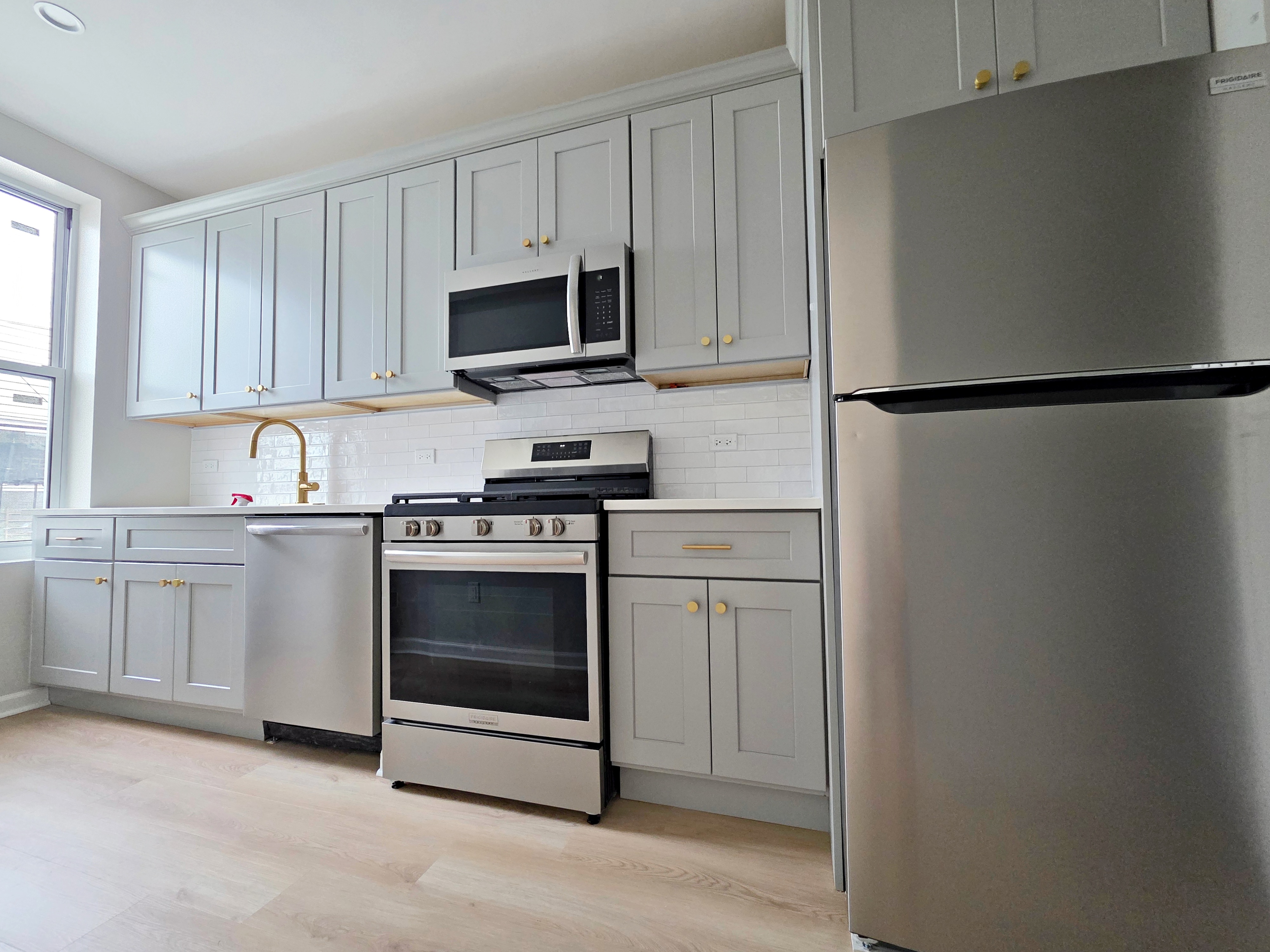 733 Metropolitan Avenue, Unit 3 Brooklyn, NY 11211 - Photo 6 of 13 a kitchen with white cabinets and stainless steel appliances