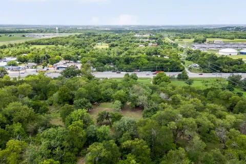 a view of a lush green forest with trees and houses
