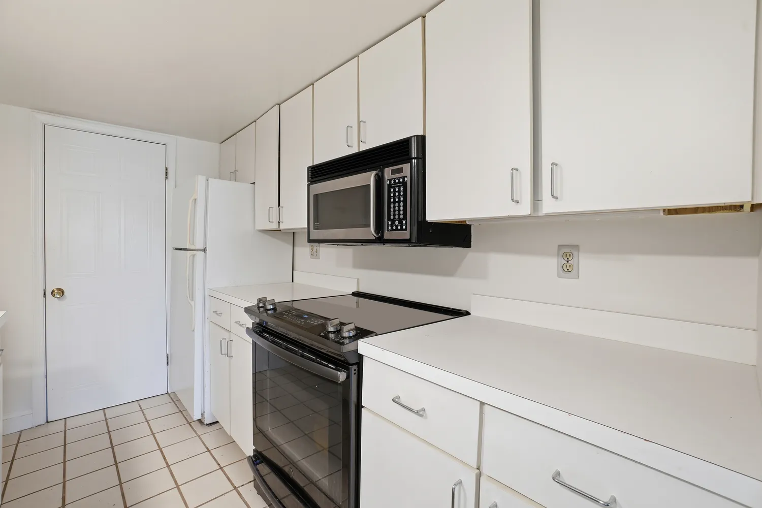 a kitchen with granite countertop white cabinets and stainless steel appliances