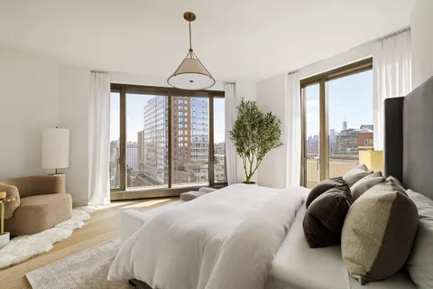 a bedroom with a bed and a large window