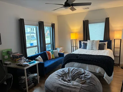 a bedroom with a bed two lamps and a couch