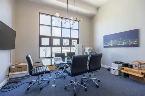 a view of a workspace with furniture and a window
