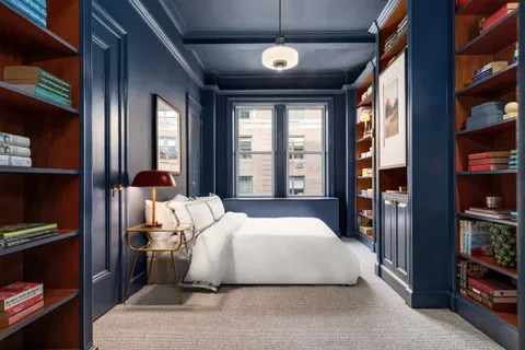 a bedroom with a large bed and a book shelf