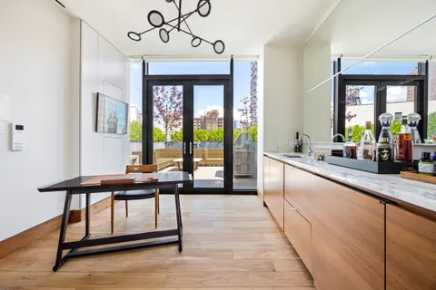 a living room with stainless steel appliances granite countertop furniture a fireplace and a large window