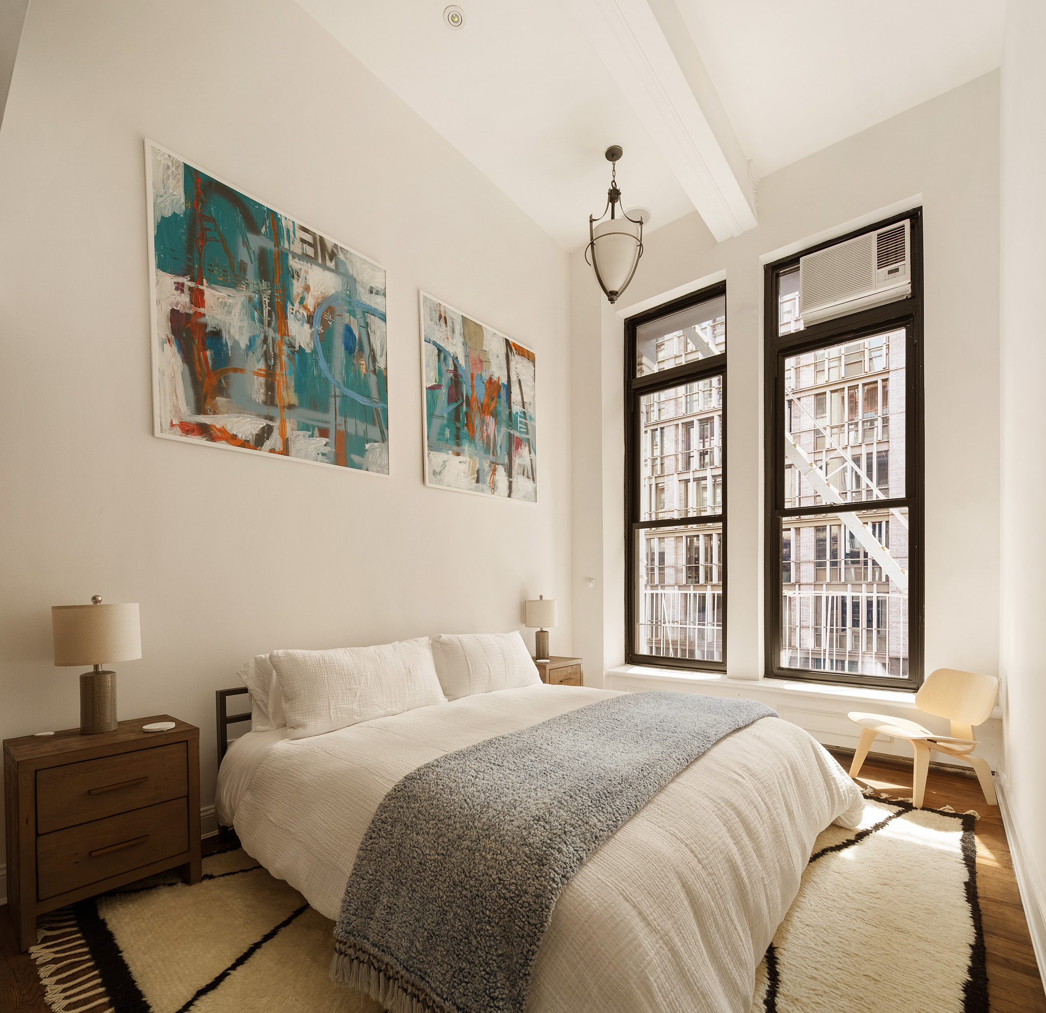 250 Mercer Street, Unit C302 Manhattan, NY 10012 - Photo 7 of 24 a bedroom with a bed wooden floor and window