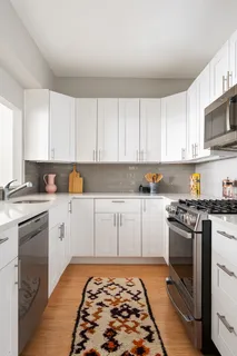 a kitchen with stainless steel appliances granite countertop a stove and white cabinets