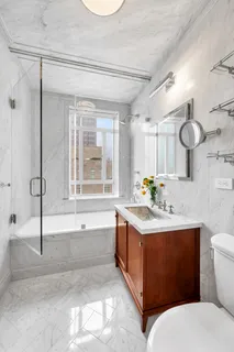 a bathroom with a granite countertop sink mirror vanity bathtub and a toilet