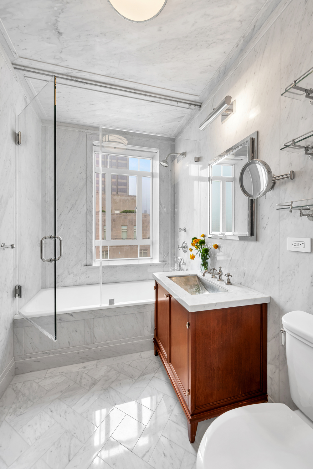 25 Central Park West, Unit 21J Manhattan, NY 10023 - Photo 30 of 37 a bathroom with a granite countertop sink mirror vanity bathtub and a toilet