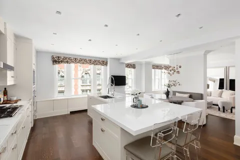 a large white kitchen with a table and chairs