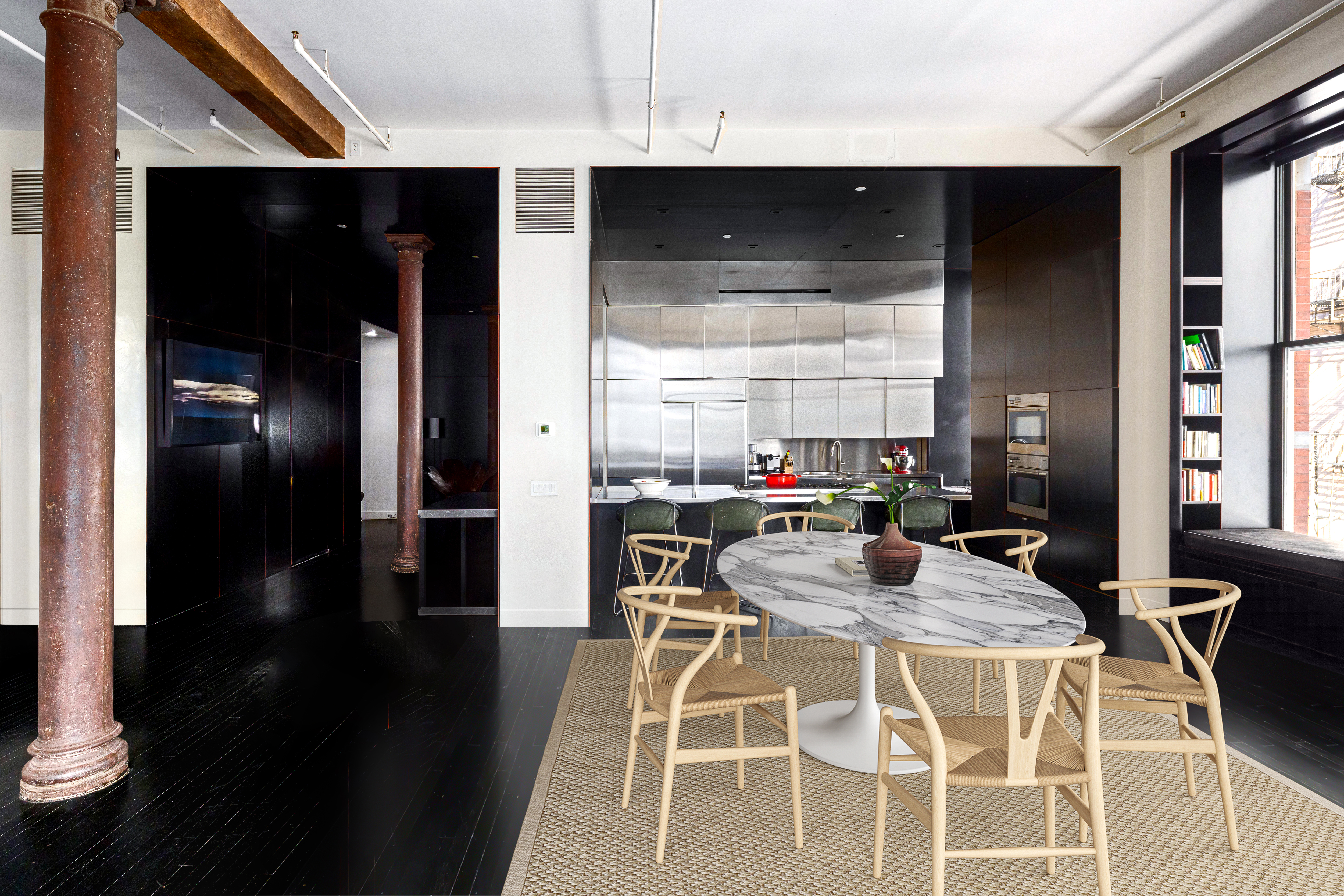 76 Crosby Street, Unit 2B Manhattan, NY 10012 - Photo 5 of 17 a kitchen with stainless steel appliances kitchen island granite countertop a refrigerator a stove and a microwave with wooden floor