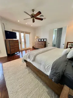 a spacious bedroom with a large bed a flat screen tv and a couch