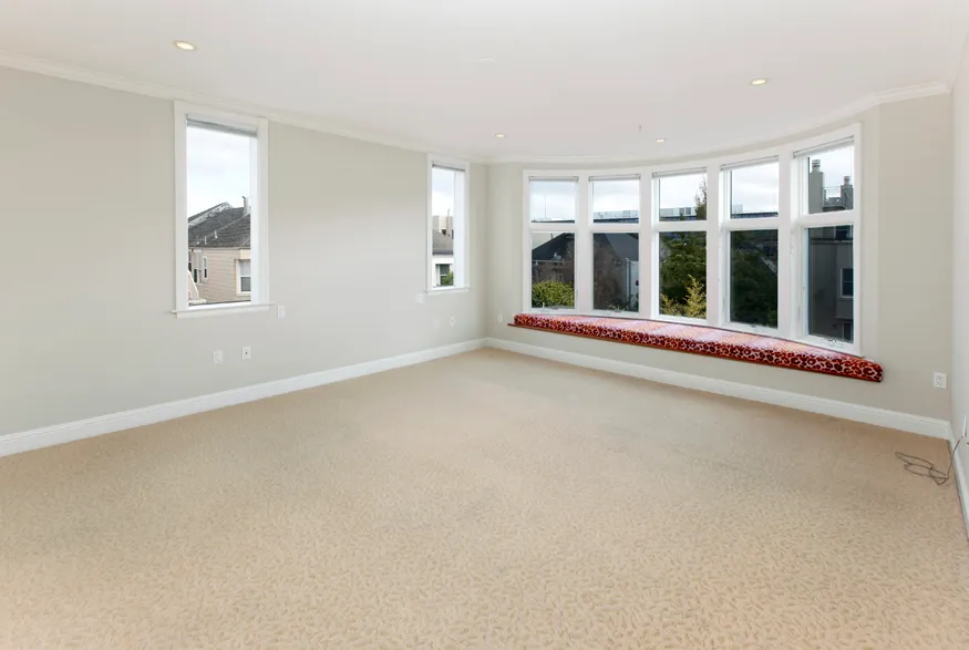 an empty room with floor to ceiling windows and chandelier