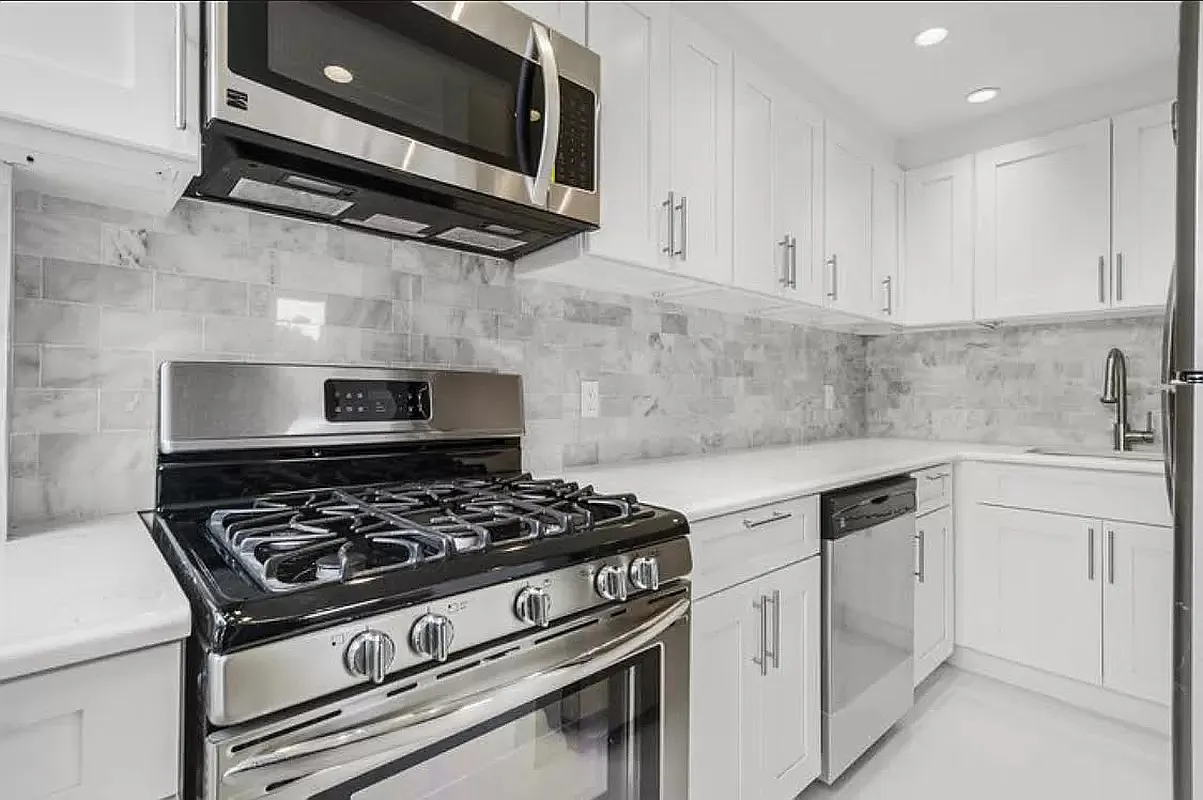 300 East 90th Street, Unit 6D Manhattan, NY 10128 - Photo 3 of 7 a white stove top oven sitting inside of a kitchen