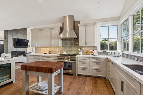 a kitchen with stainless steel appliances granite countertop a stove a sink and white cabinets