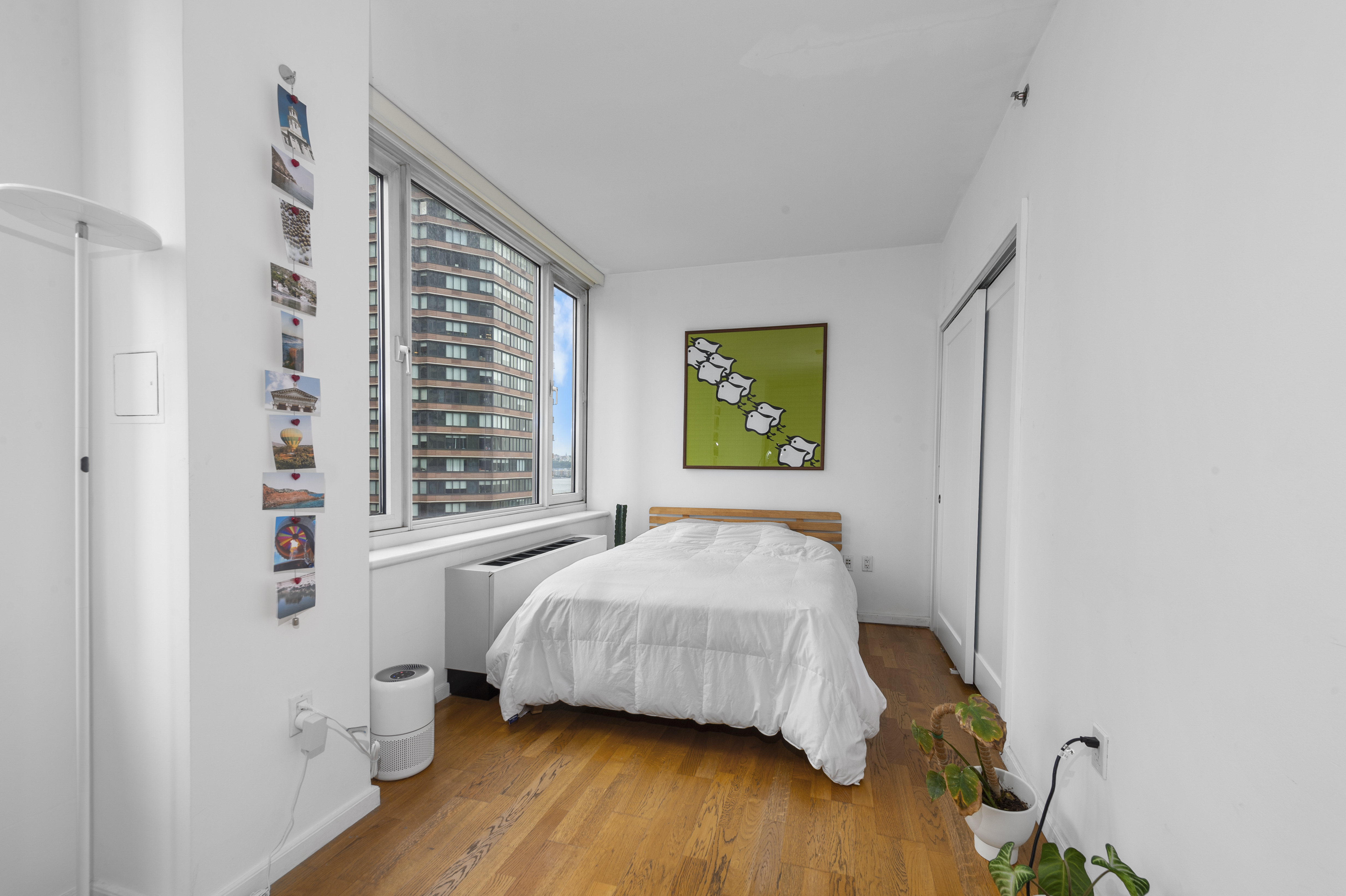 635 West 42nd Street, Unit 14K Manhattan, NY 10036 - Photo 3 of 19 a bedroom with a bed and wooden floor