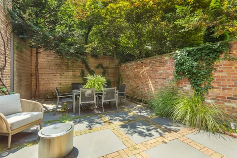 a view of a patio with table and chairs potted plants and tree