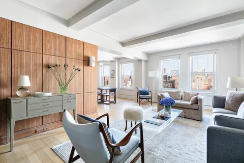 a living room with furniture a wooden floor and a large window