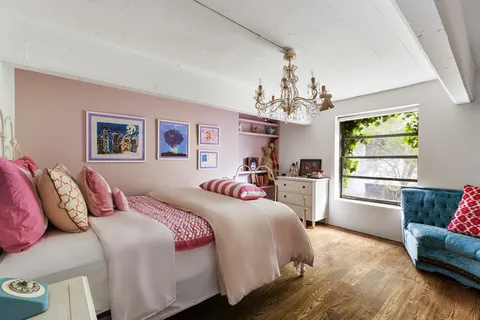 a bedroom with a bed and a chandelier