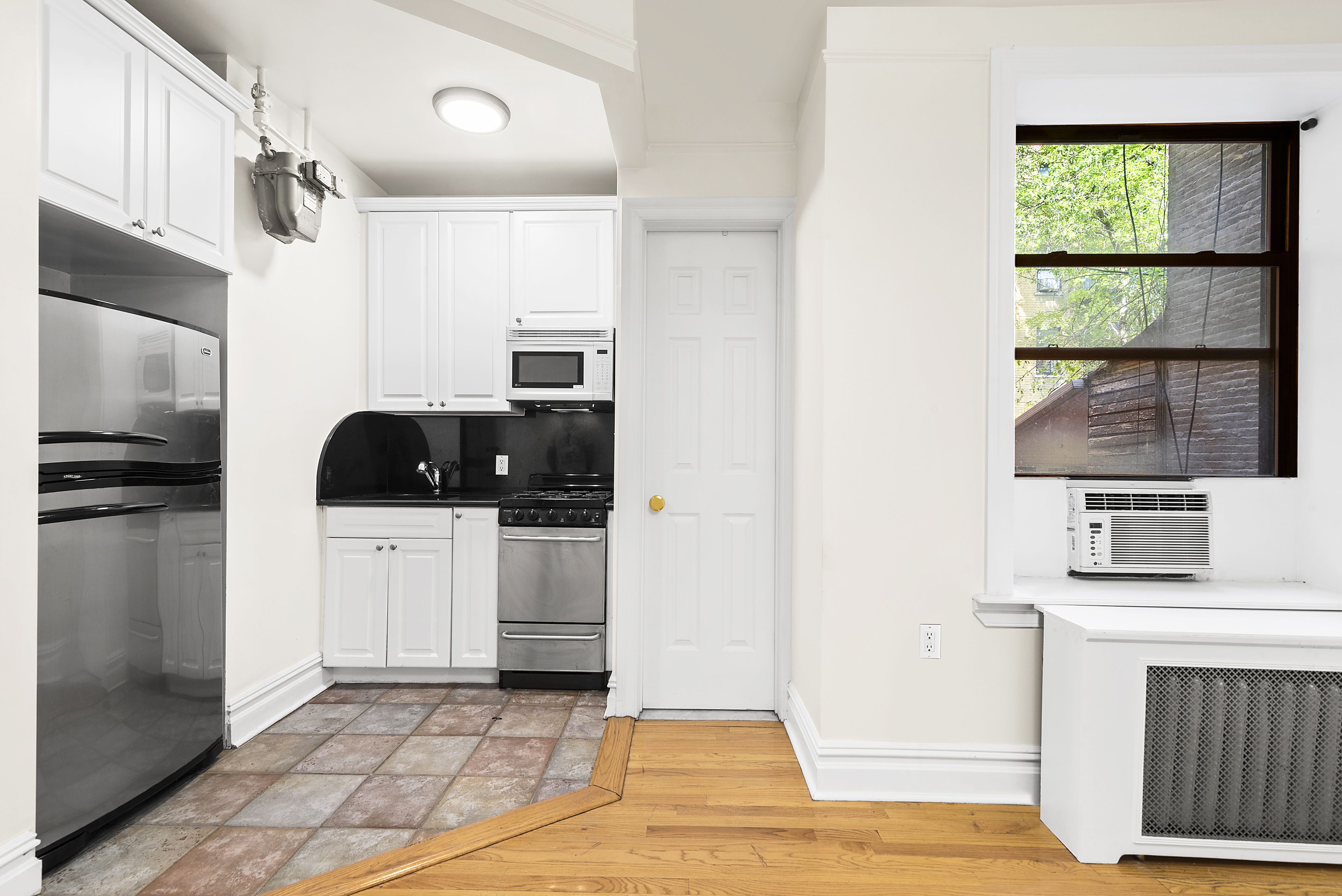 680 Riverside Drive, Unit 1E Manhattan, NY 10031 - Photo 5 of 6 a kitchen with stainless steel appliances a stove a microwave and a refrigerator