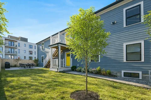 a view of a house with backyard and sitting area