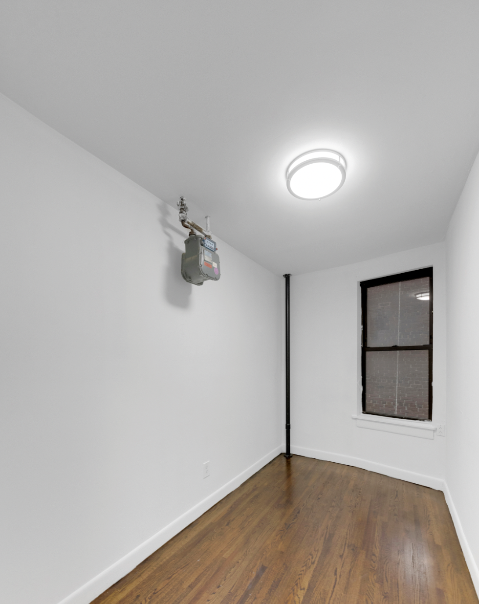 24 East 97th Street, Unit 21 Manhattan, NY 10128 - Photo 4 of 5 a view of a room with wooden floor and white walls
