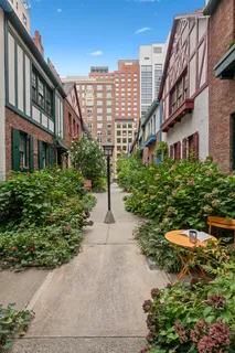 a front view of a multi story residential apartment building with yard and outdoor seating