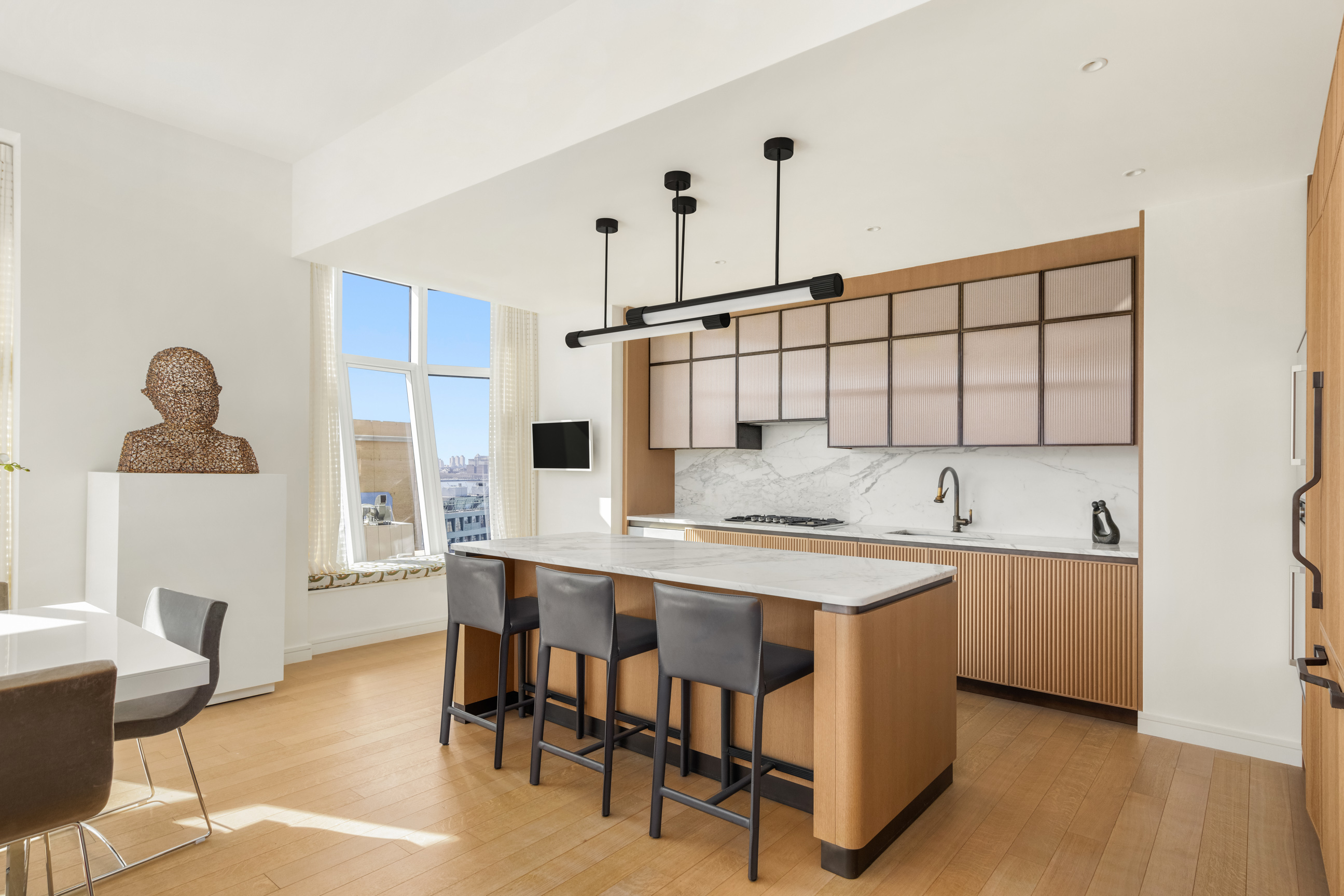 515 West 18th Street, Unit 1102 Manhattan, NY 10011 - Photo 4 of 18 a kitchen with a table chairs refrigerator and cabinets