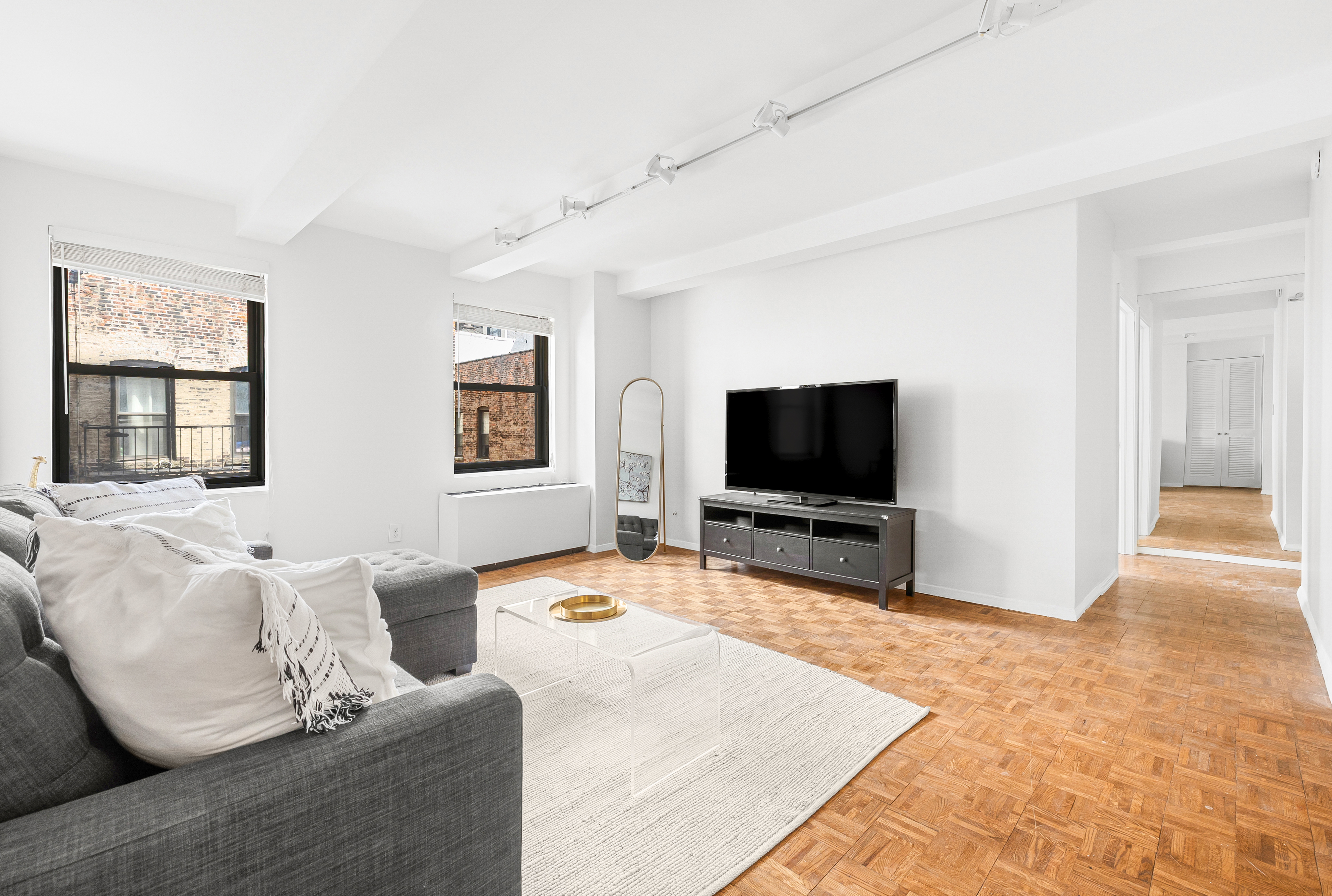 235 East 49th Street, Unit 6G Manhattan, NY 10017 - Photo 11 of 22 a living room with furniture and a flat screen tv